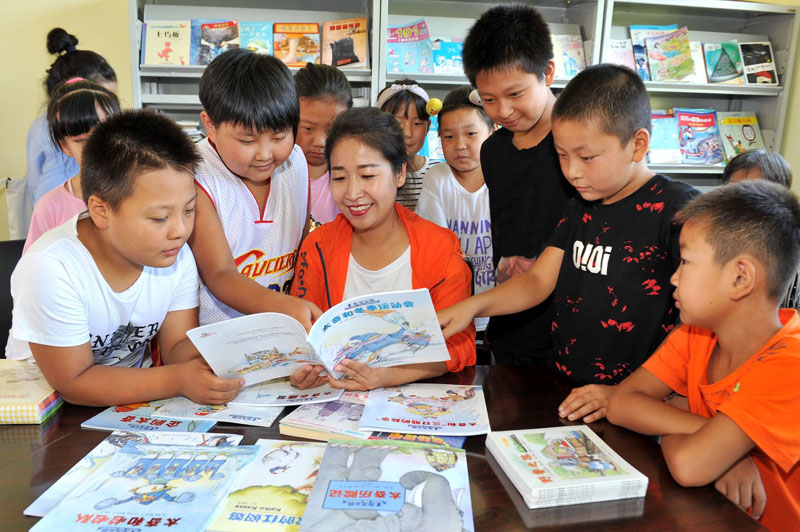 在暑假的公益課堂活動(dòng)中，王嬌給村里的孩子講故事