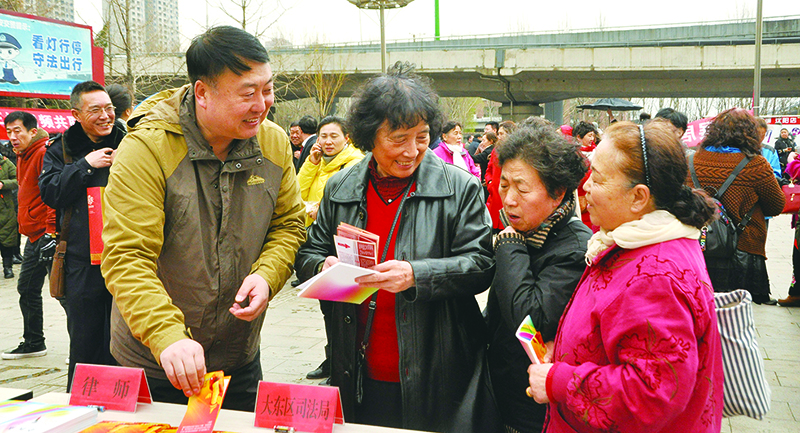 張京濤(左)到街頭開(kāi)展普法宣傳活動(dòng)