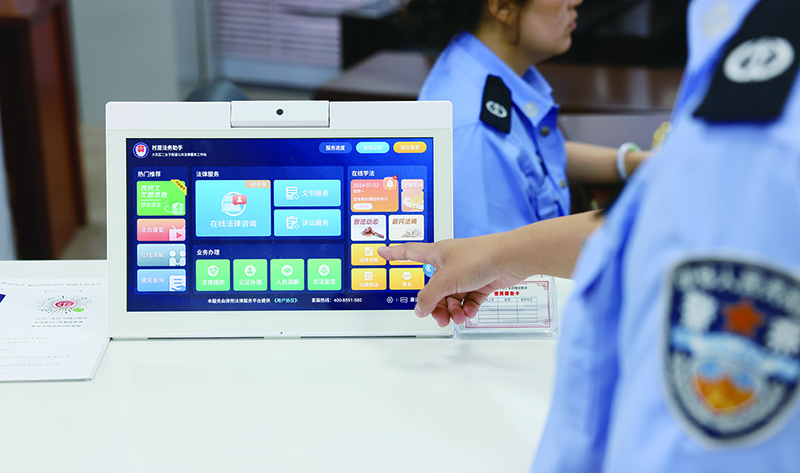 司法所工作人員介紹“律兜” 功能 本報(bào)記者孟浩 攝