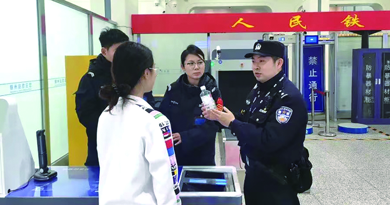 二題圖，童秋華（右）在向旅客講解安檢規(guī)定