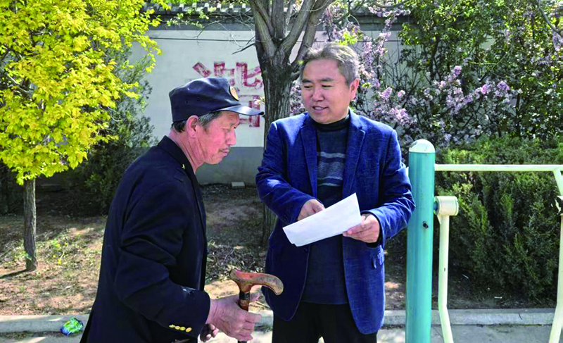 村工作人員認(rèn)真記錄村民的意見。